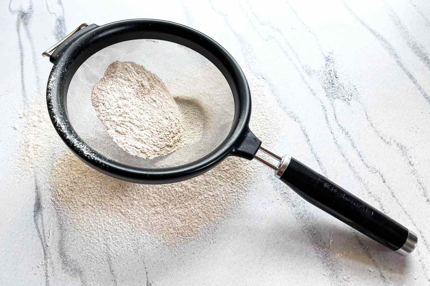 KitchenAid Classic Strainer with flour on a marble surface