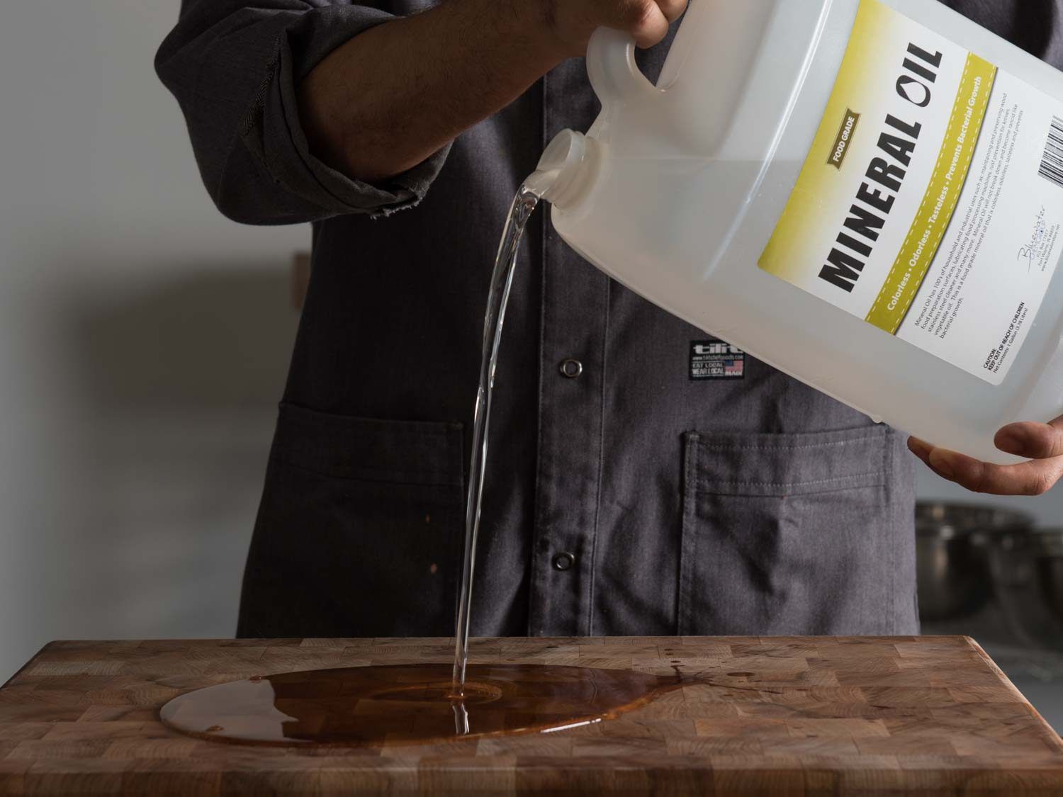 Pouring mineral oil onto wood cutting board
