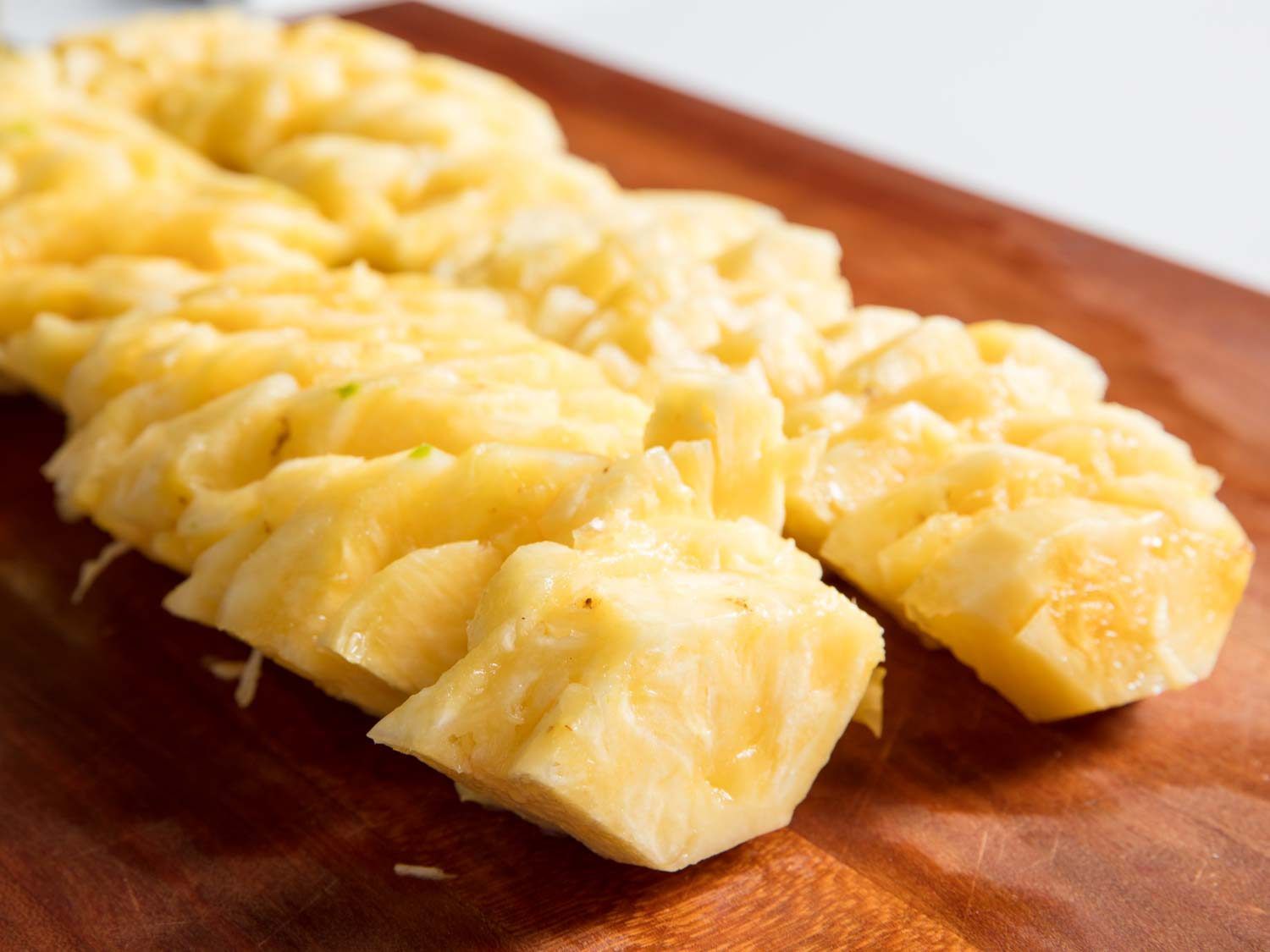 Sliced pineapple on a cutting board.