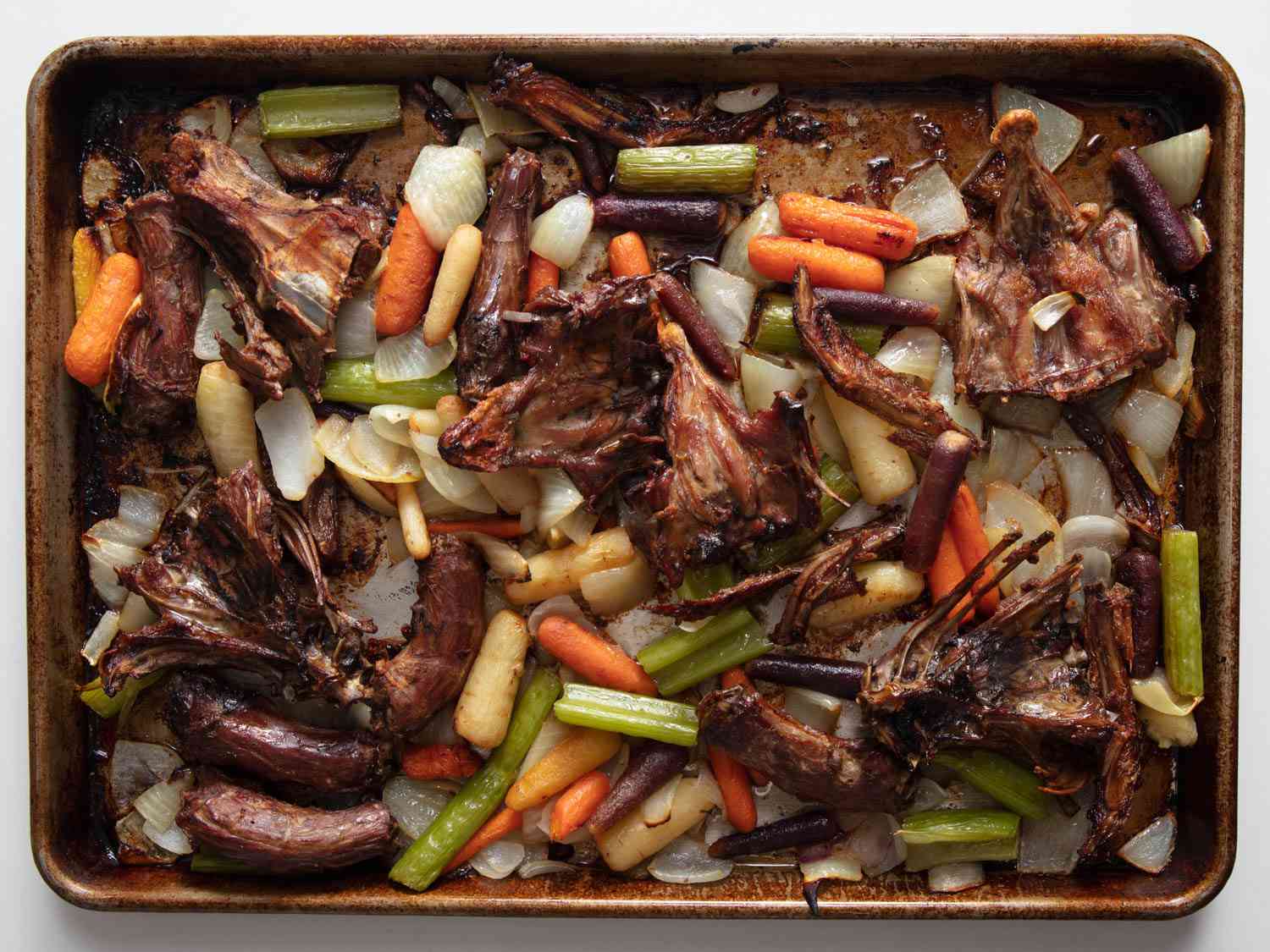 Roated duck bones and mire poix on a tray.