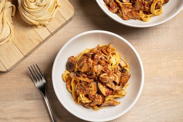 Two bowls filled with pasta and mushroom ragù.
