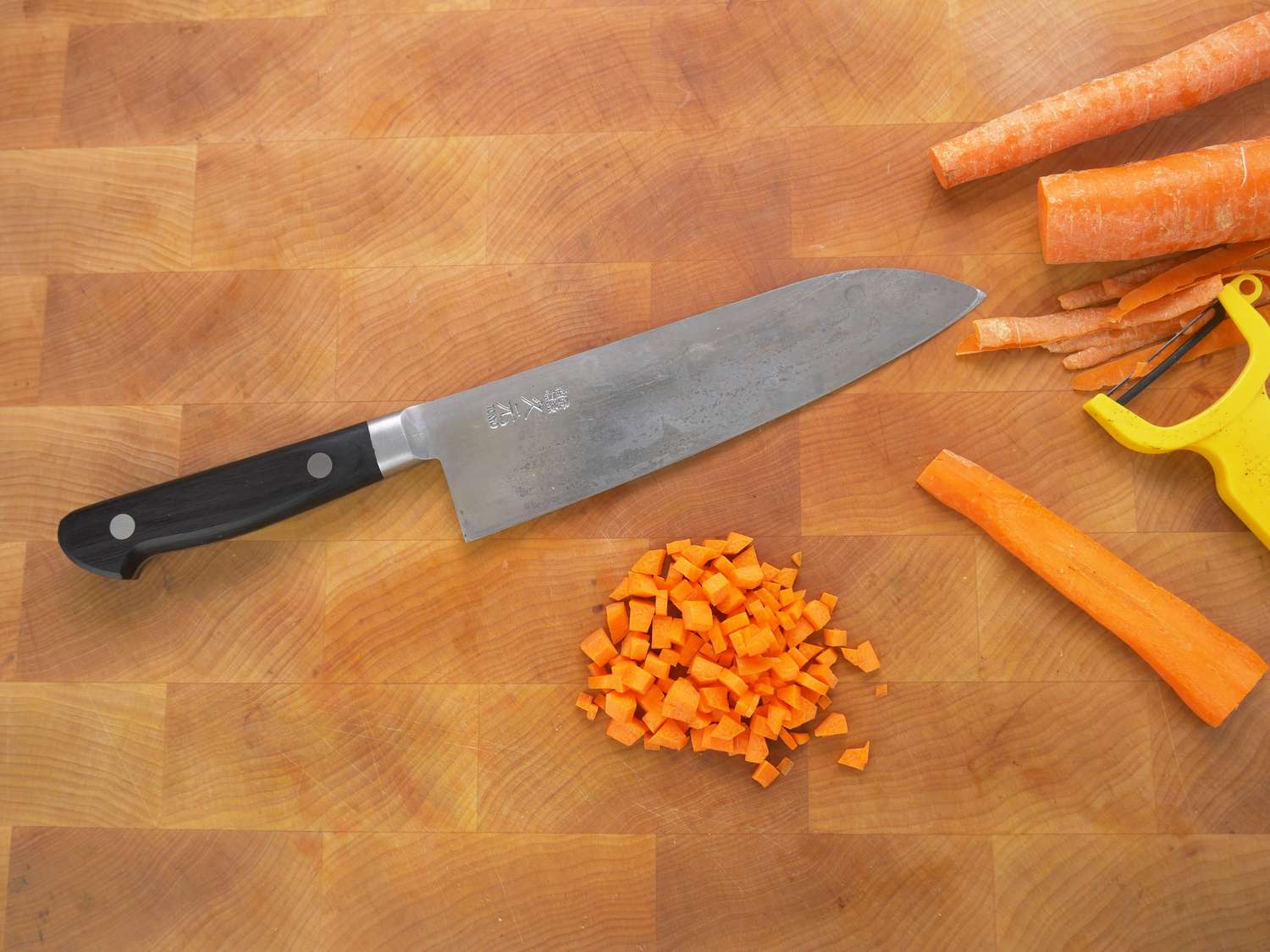 morihei hisamoto knife on a wooden cutting board with carrots