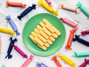 a plate of pastillas de leche surrounded by more candy in wrappers