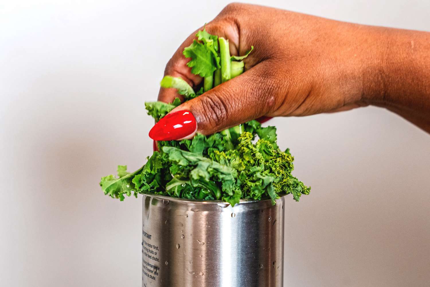 Kale being added to the feeding chute of the Breville 800JEXL juicer