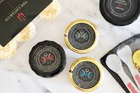 A collection of Caviar Co products: crème fraîche, mother-of-pearl spoons, a caviar key, prepared blinis, royal white sturgeon caviar, osetra caviar, and kaluga hybrid caviar
