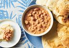 Ful medames served inside a bowl with a side of toasted pita 
