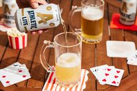 a hand pouring out athletic lite into a glass