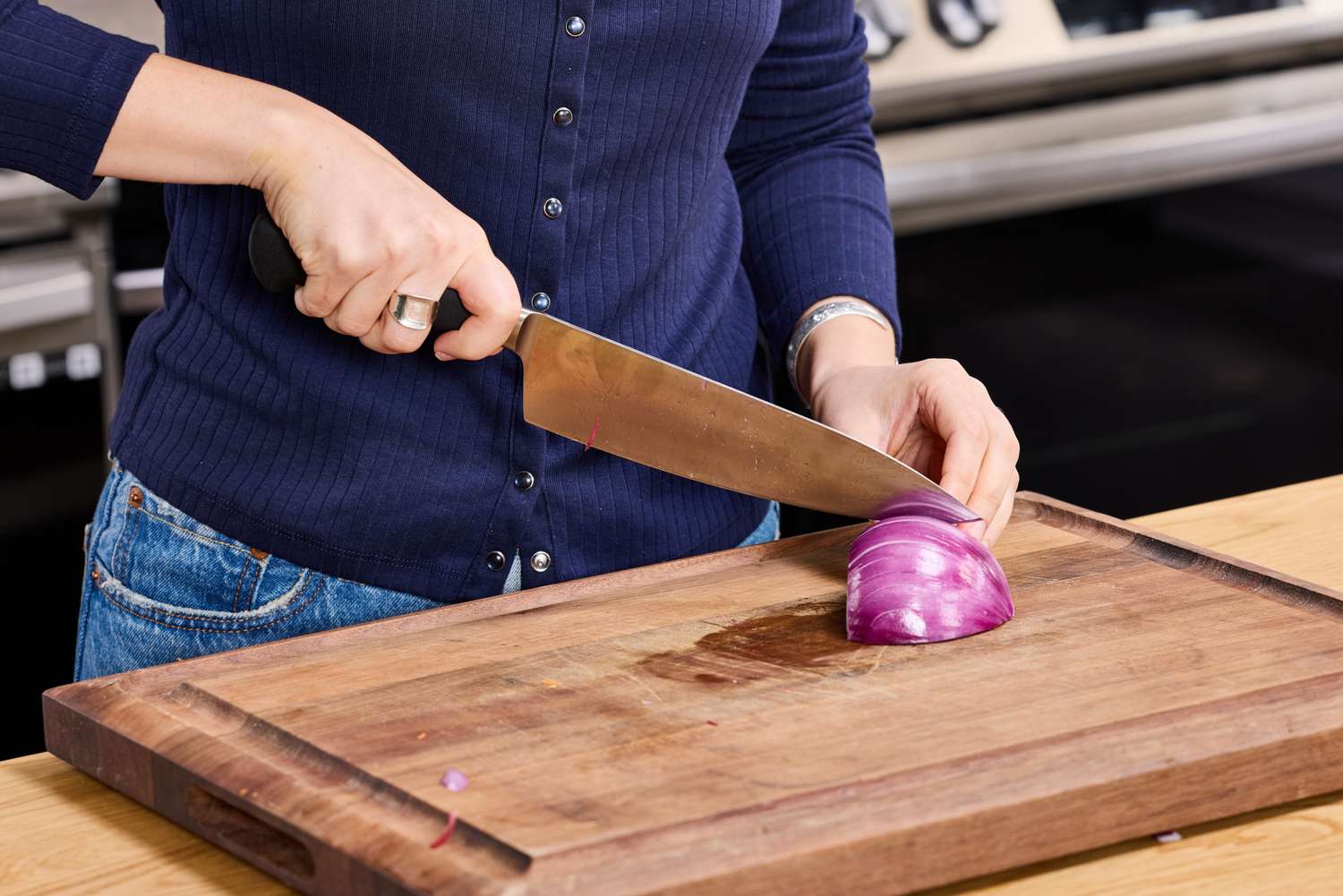 A person dices red onion using the Mercer Culinary 8-Inch Genesis Chef's Knife