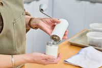 A person removes the bottom from the Timemore C2 Max Manual Grinder