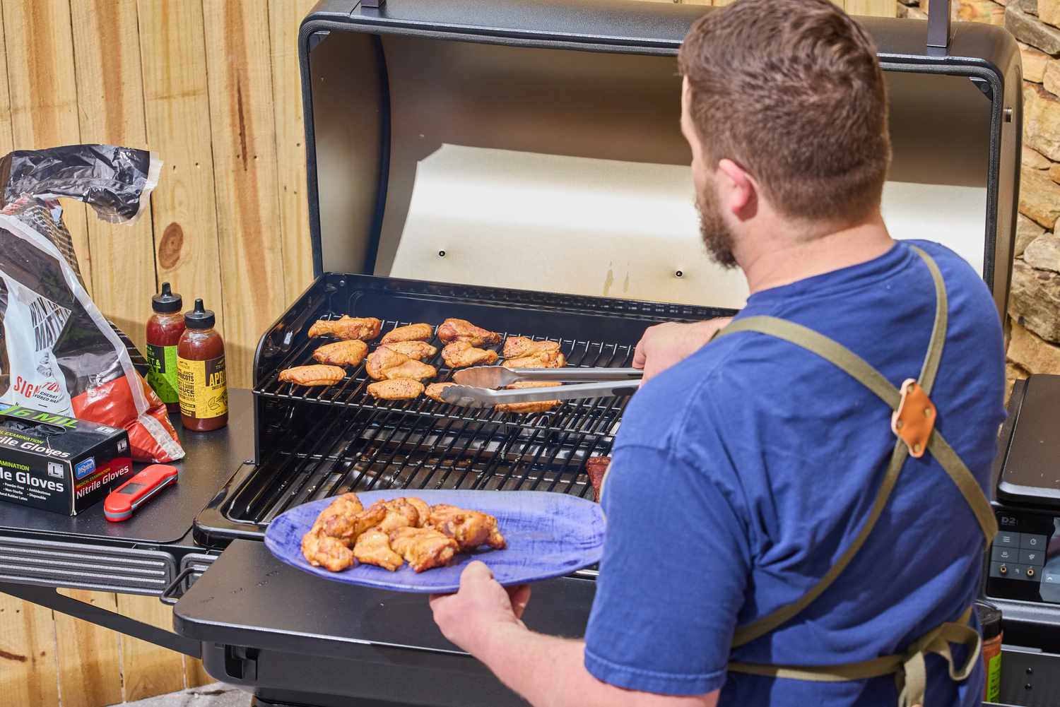 A person cooks wings in the Traeger Ironwood XL