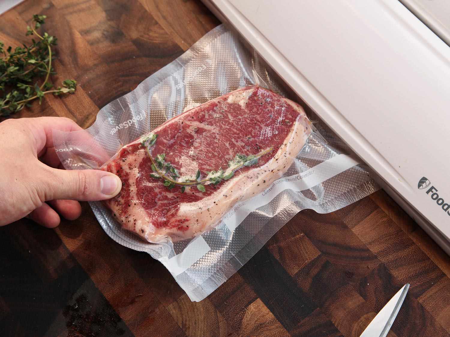 Raw steak in a sous vide bag being vacuum sealed. 