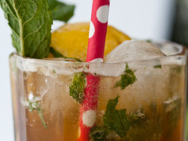 Closeup of the rim of a glass containing a Pimm's lemon mojito cocktail.