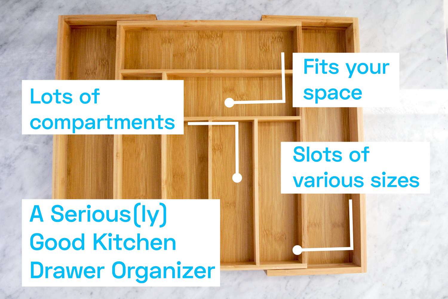 A wooden kitchen drawer organizer on a marble surface.