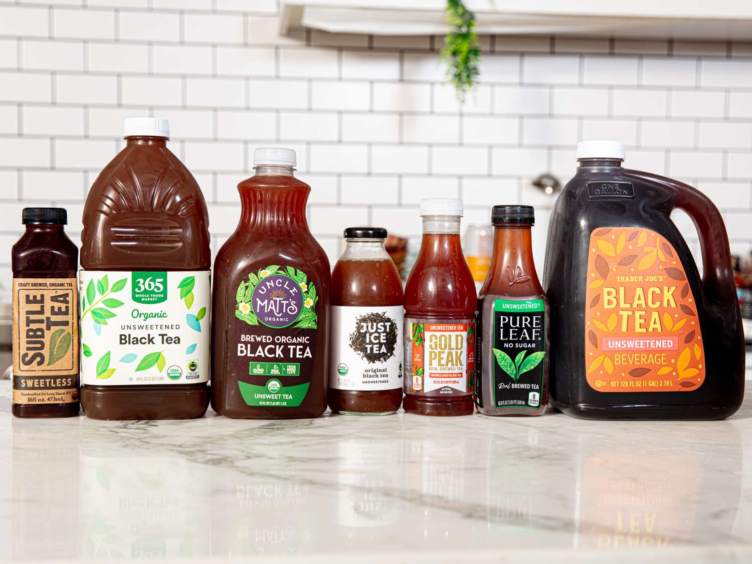 A selection of bottled and jugged black teas displayed on a counter