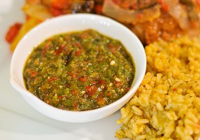 Small bowl of Puerto Rican sofrito next to rice on a plate.