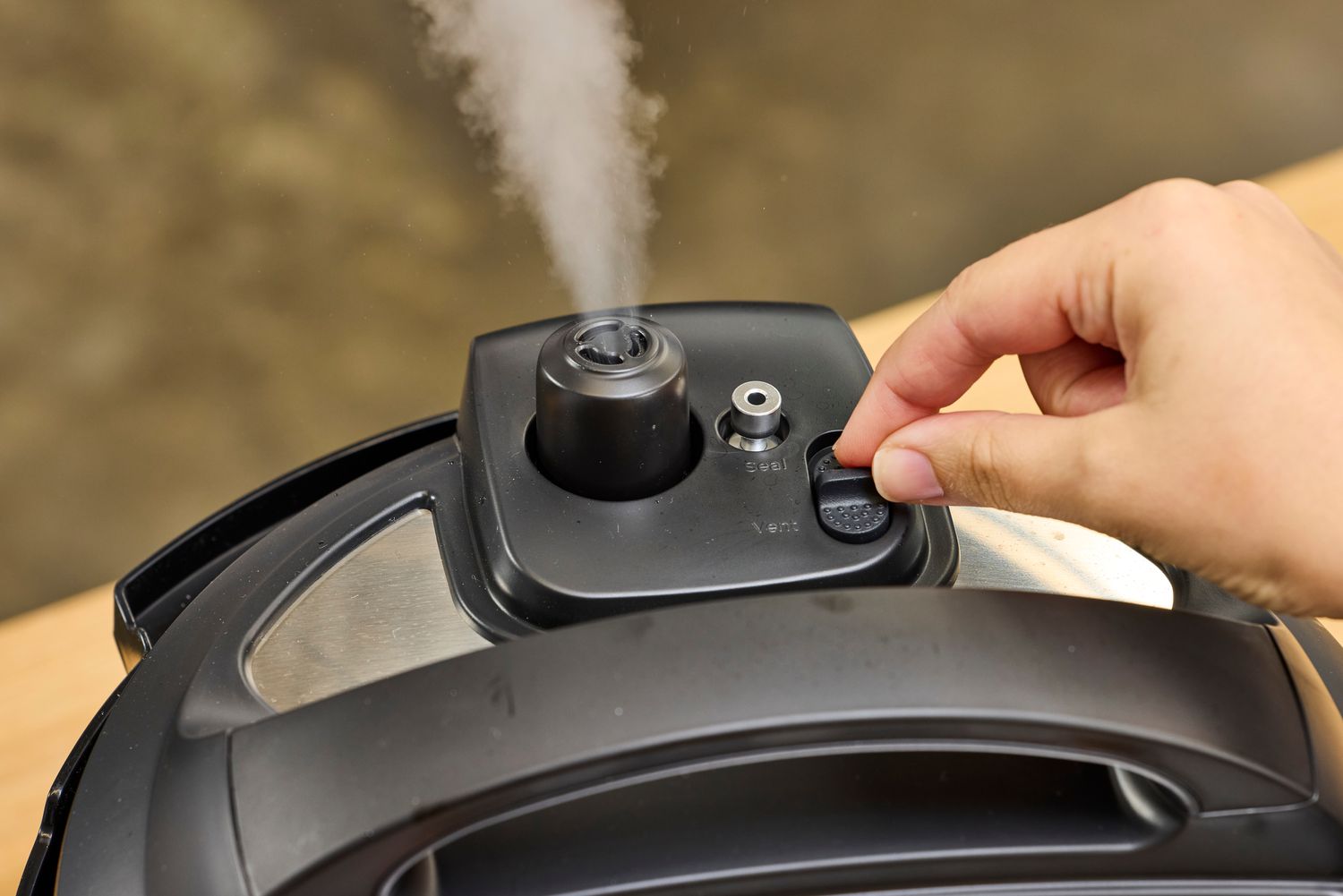 A person flips a switch on the Instant Pot RIO 6-quart Multicooker