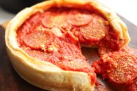 A closeup of a pizza made in the LloydPans Chicago Style Deep Dish Pizza Pan