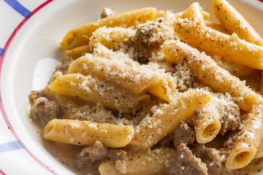 A bowl of penne pasta alla norcina, or creamy pasta with sausage. 