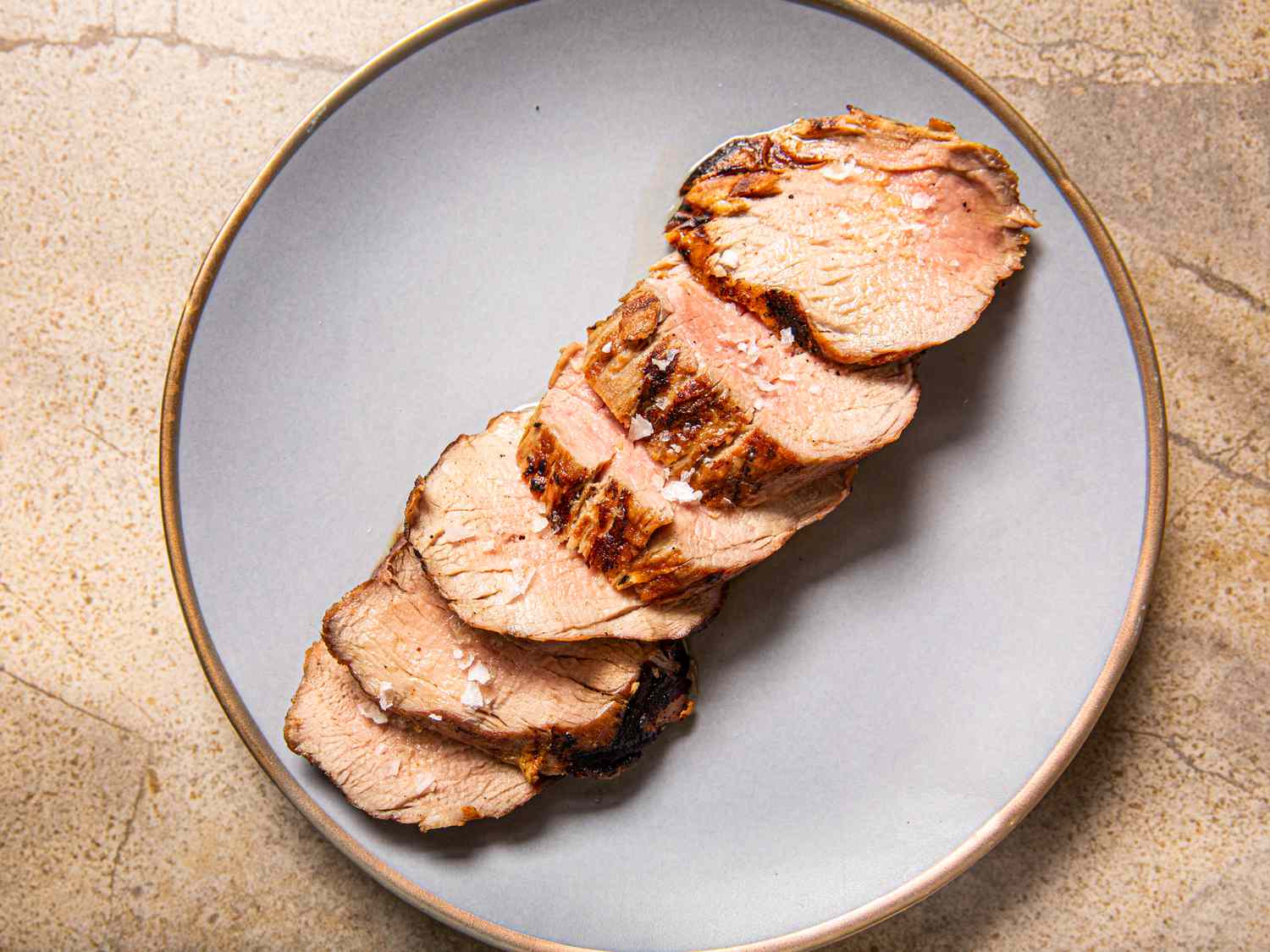 Slices of grilled pork tenderloin on a plate.