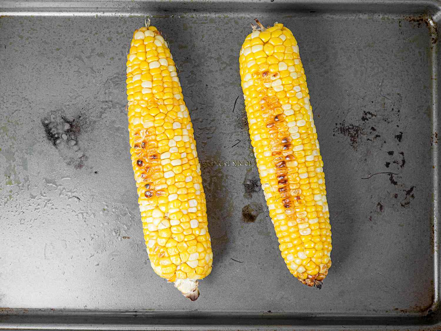Roasted corn on a rimmed baking sheet
