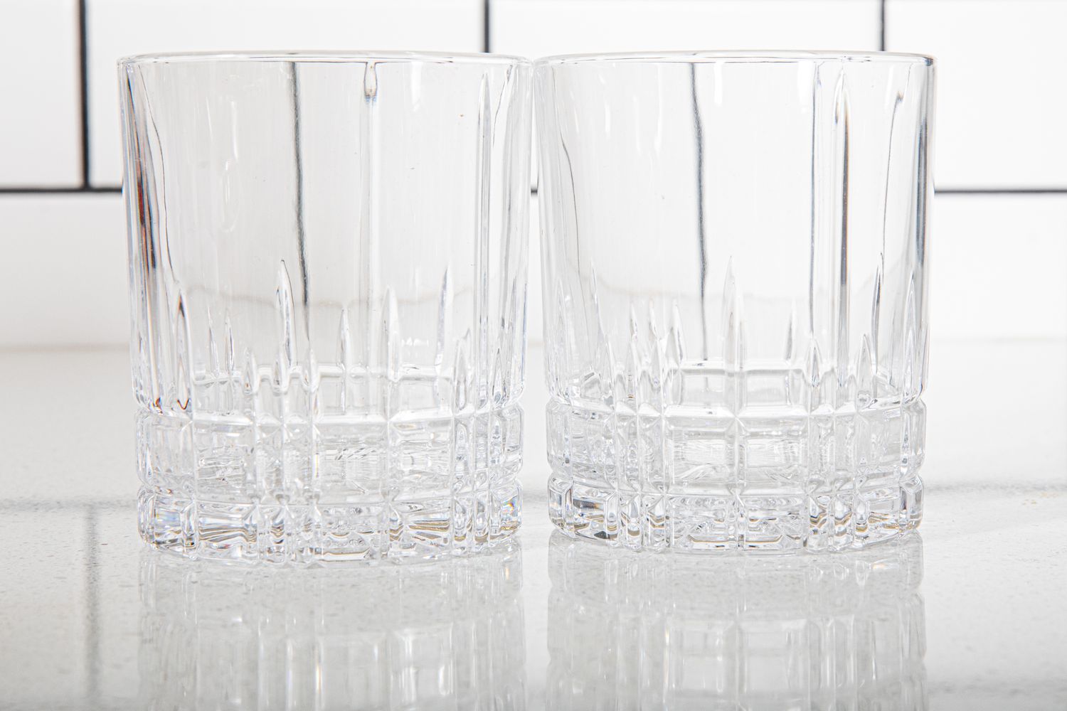 Two old fashioned glasses on a kitchen coutnertop