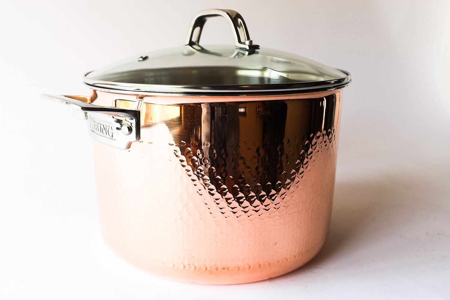 A copper cookware pot with a lid and a handle