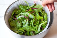 removing the basket with greens from the bowl
