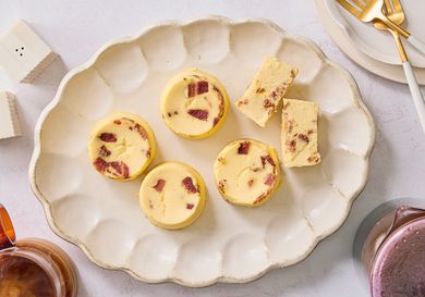 Overhead off egg bites on a scalloped platter with coffee, smaller plates and gold forks to the side