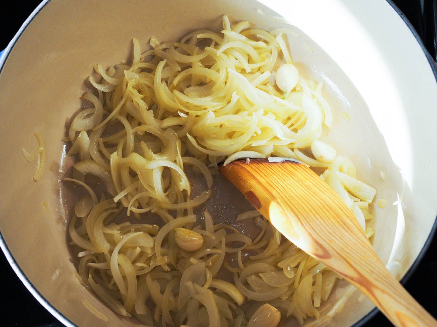 Onions and garlic are cooked in a Dutch oven.