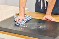 A person wipes cleaning product from the GelPro NewLife Bio-Foam Professional Anti-Fatigue Mat