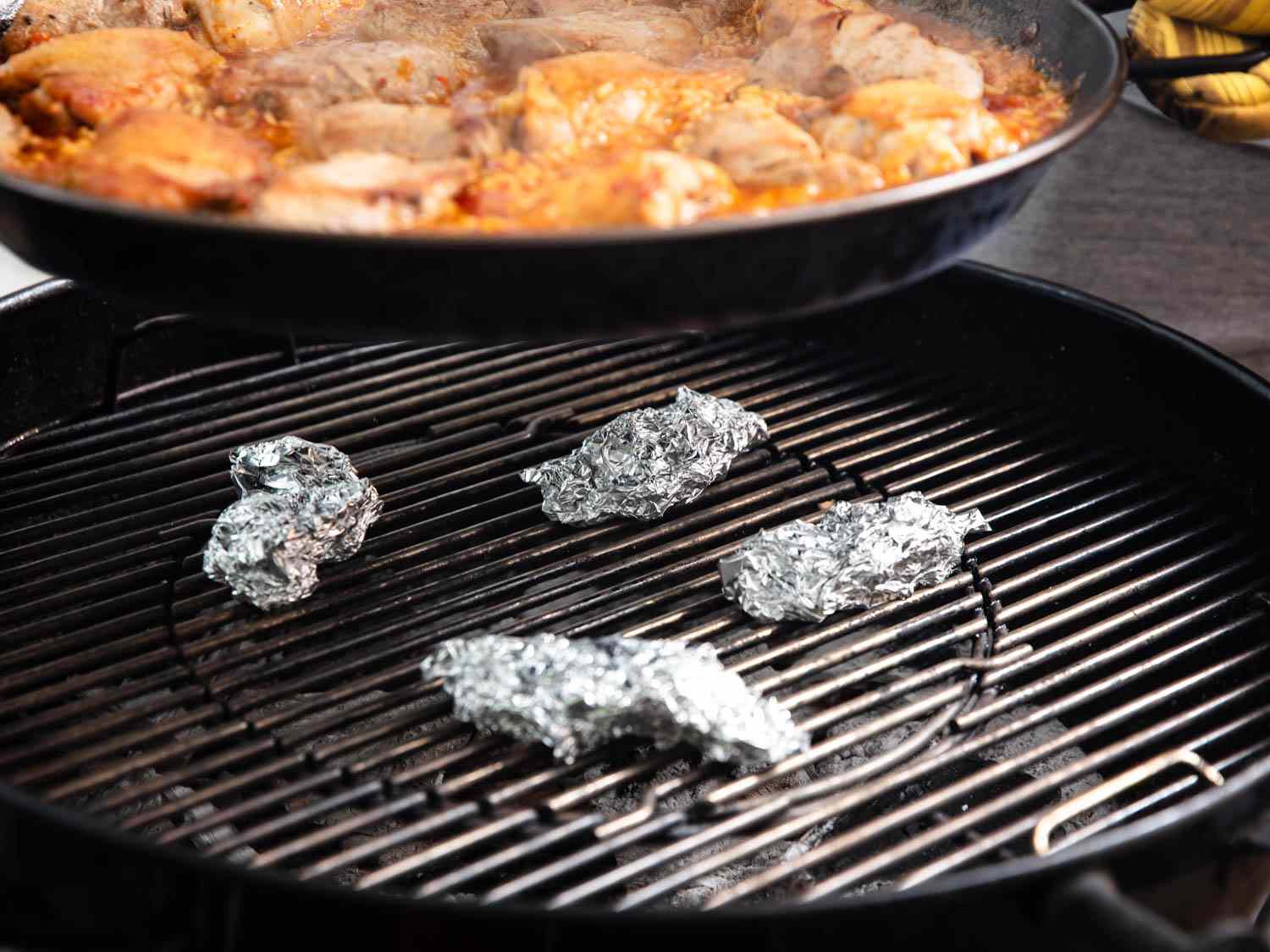 Pieces of aluminum foil lift the paella pan a little farther from the heat when necessary.