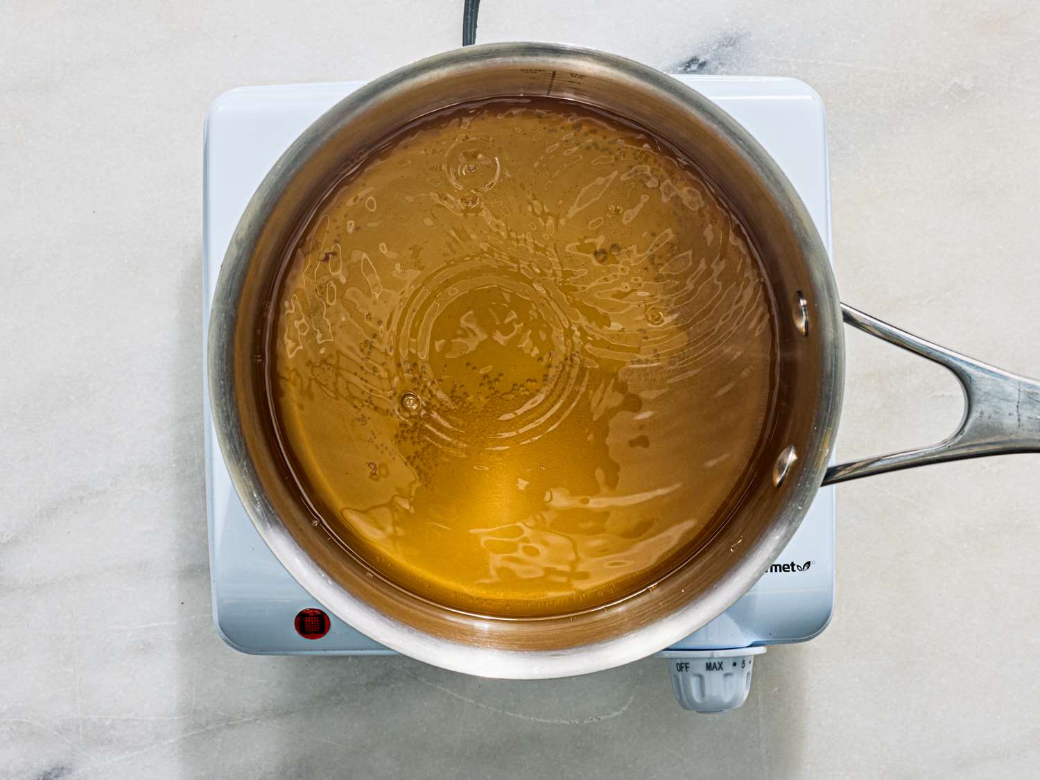 Overhead view of a pot containing a liquid mixture placed on a hot plate