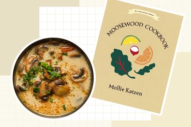 A bowl of soup and the cover of the Moosewood Cookbook featuring a title and illustrations of food elements