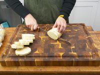 a person cutting bread on the yes4all wooden cuttingboard