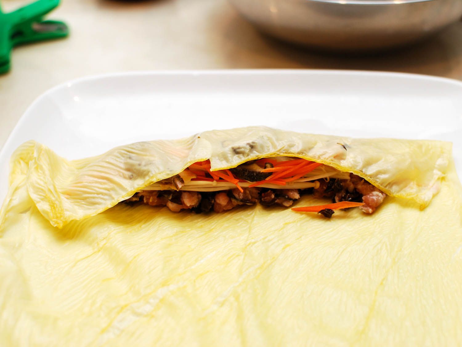 The top margin of bean curd sheet is folded over the filling.