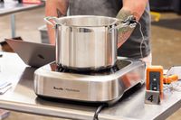A pot steaming on a Breville PolyScience induction cooktop with a thermometer