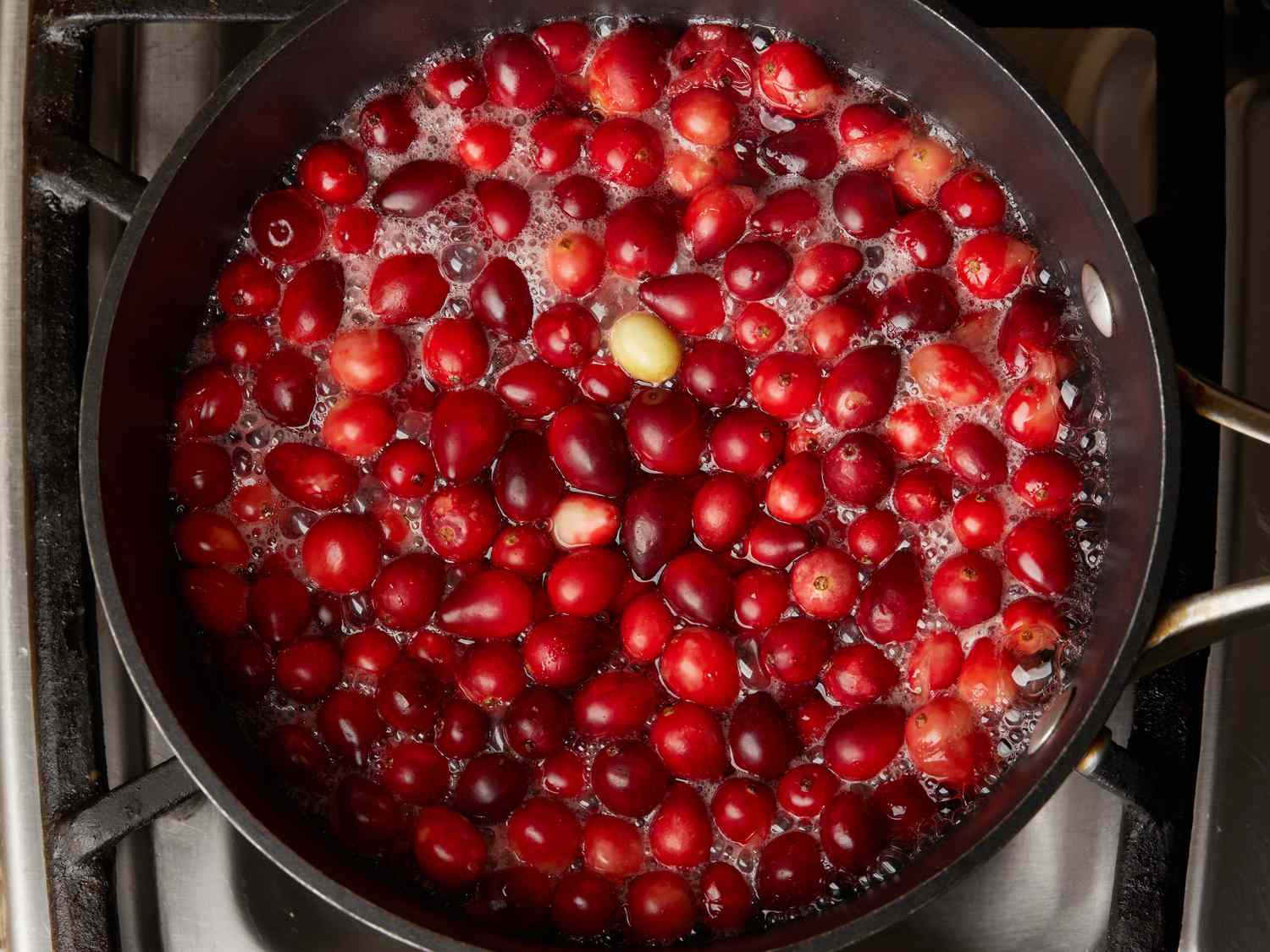cranberries and water boiling in a large saucepan