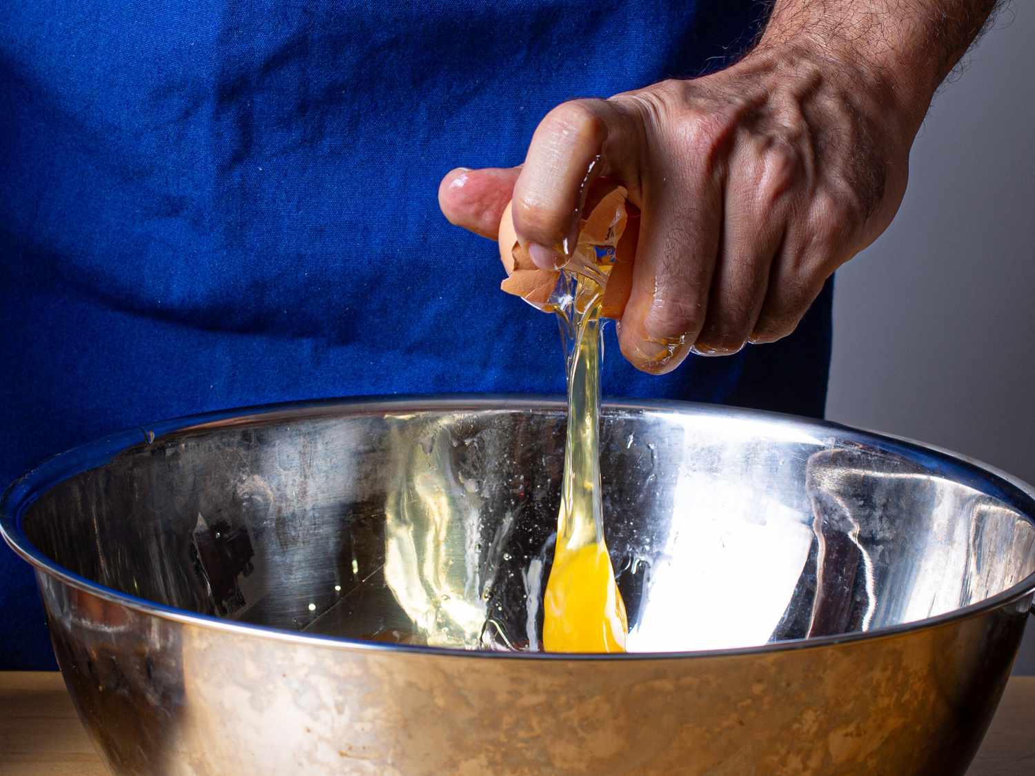 Side view of cracking an egg 