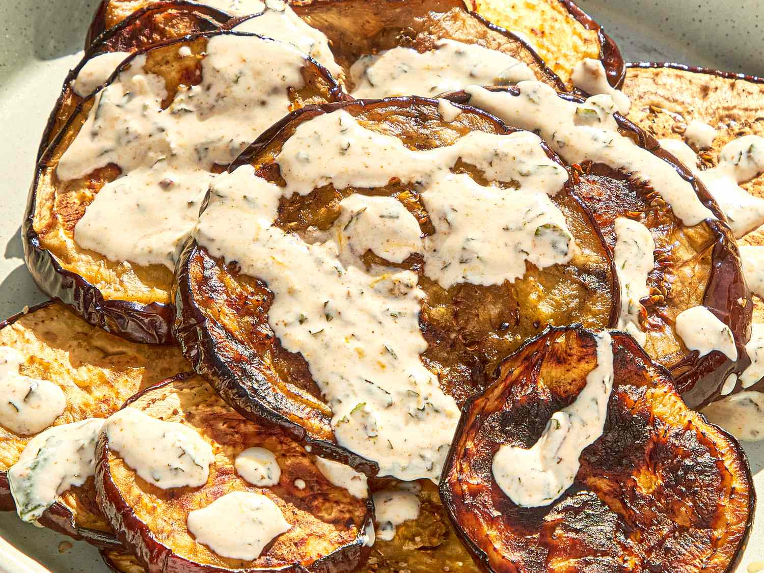 Grilled eggplant slices topped with a creamy herb sauce