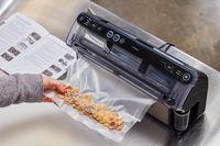 A person vacuum seals Chex Mix in the FoodSaver VS5960 Elite All-in-One Liquid+ Vacuum Sealer