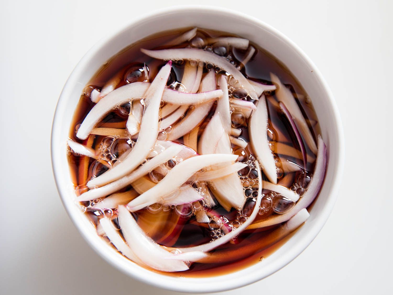 Sliced red onions marinating in vinegar.