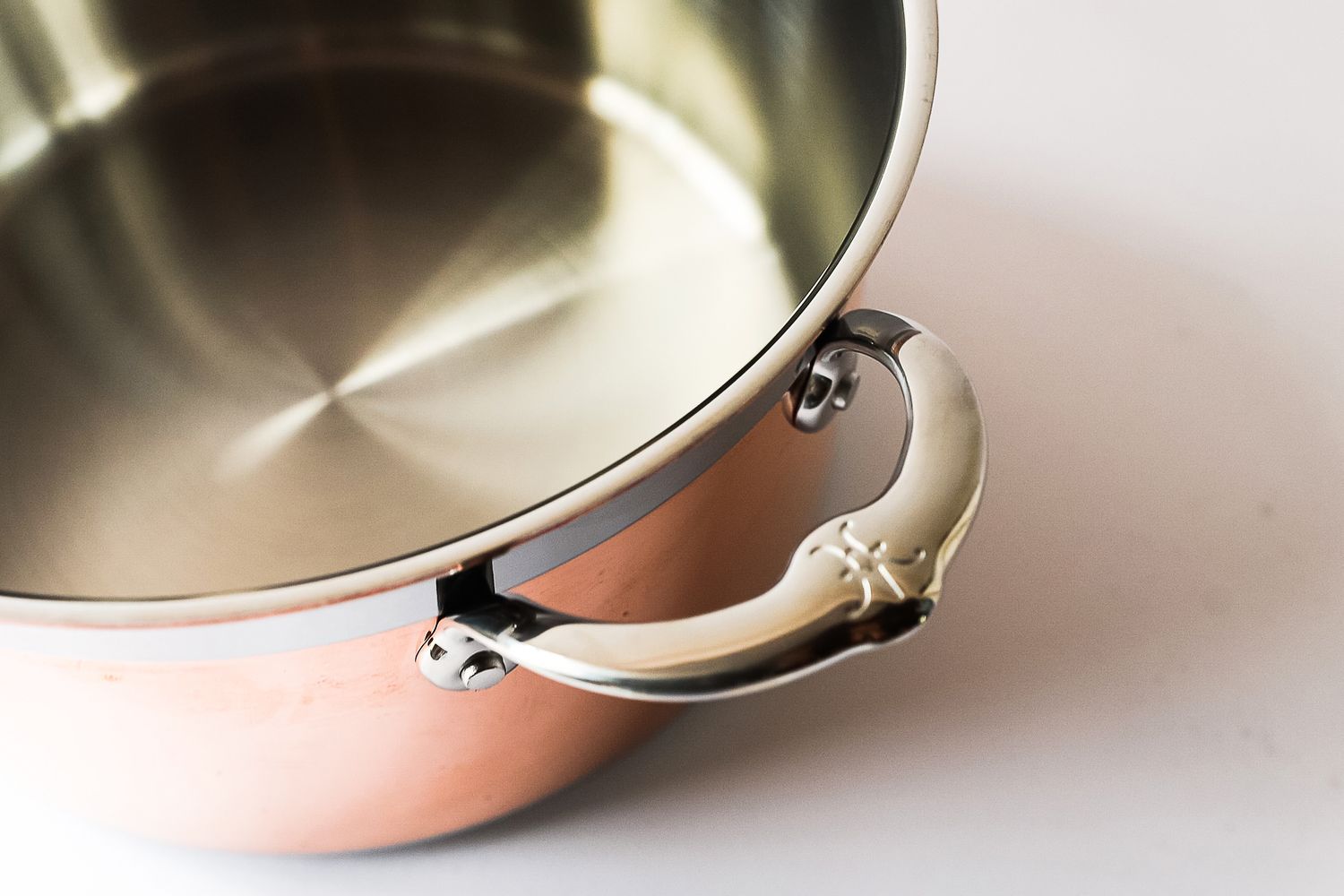 A metal pot with a shiny handle and a smooth interior surface