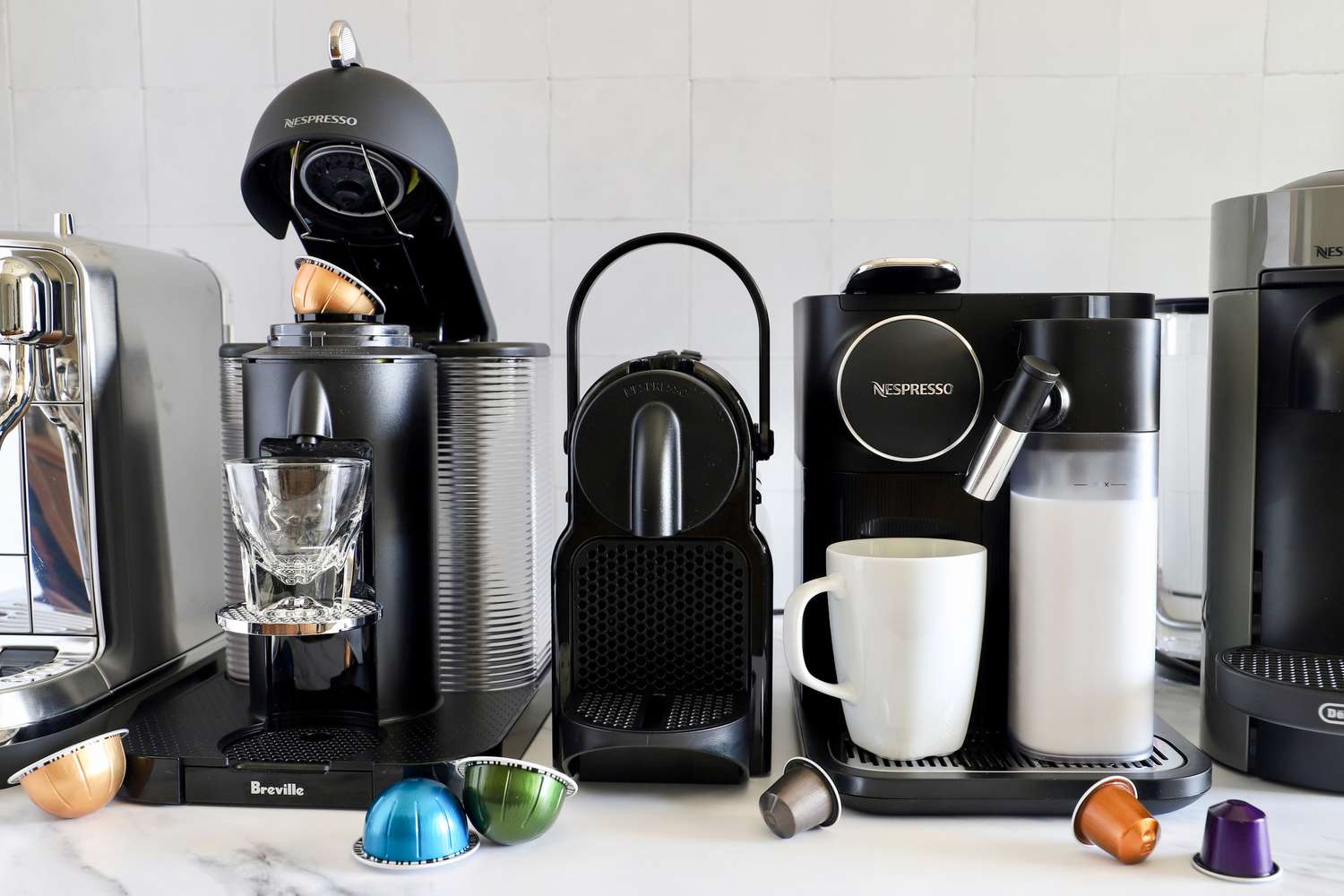 A number of Nespresso machines on a marble countertop.