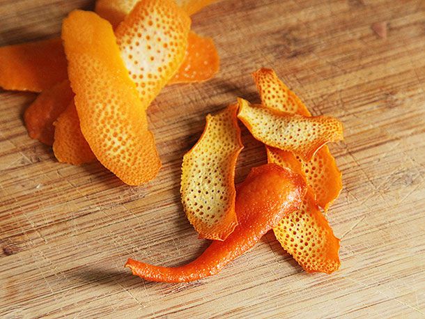 Fresh and dried orange peels on a cutting board. 