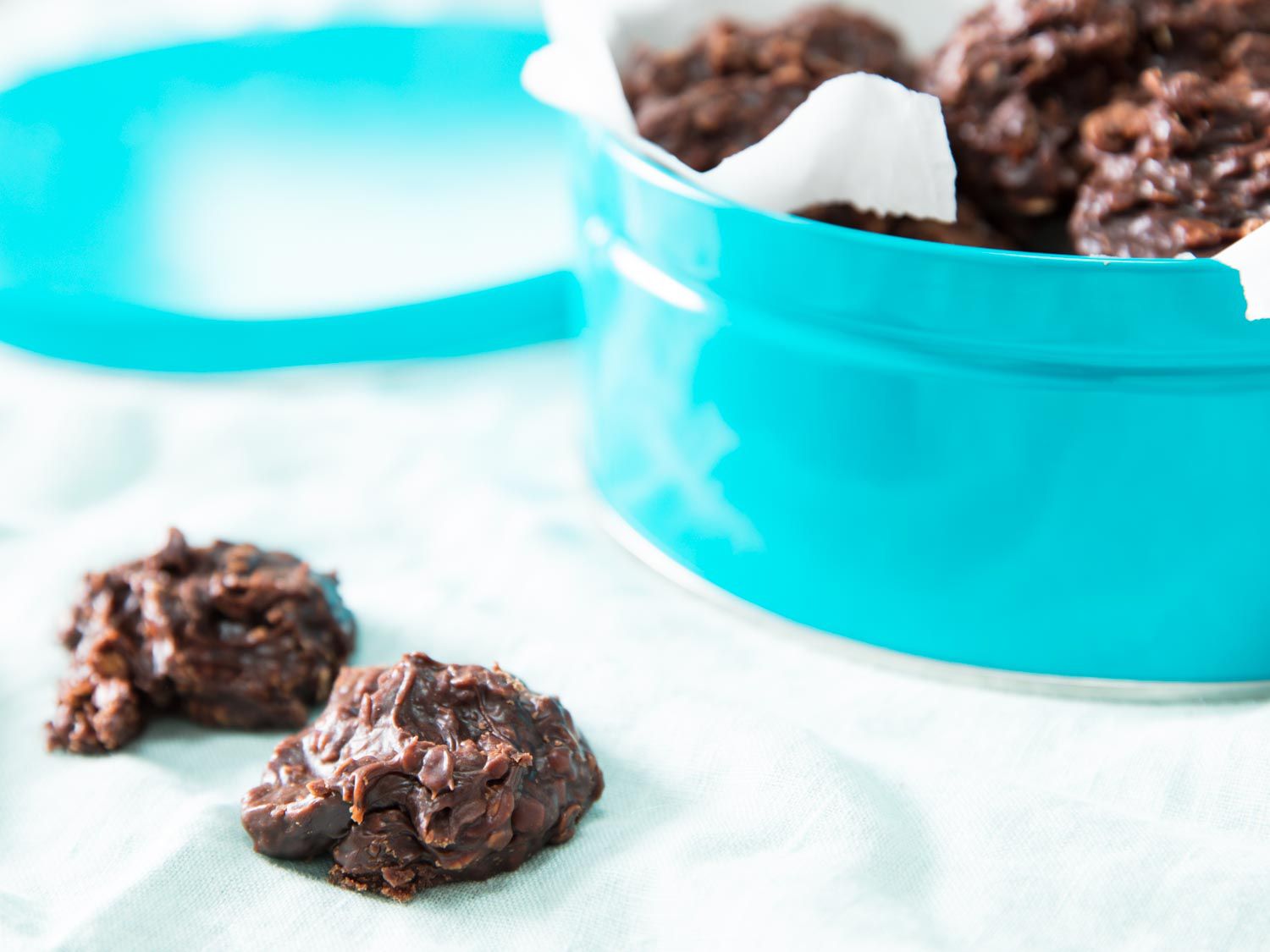 Chewy no-bake cookies next to a cookie tin.