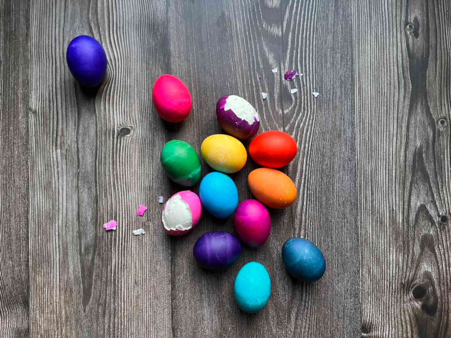 Easter eggs in various bright colors on a wooden table