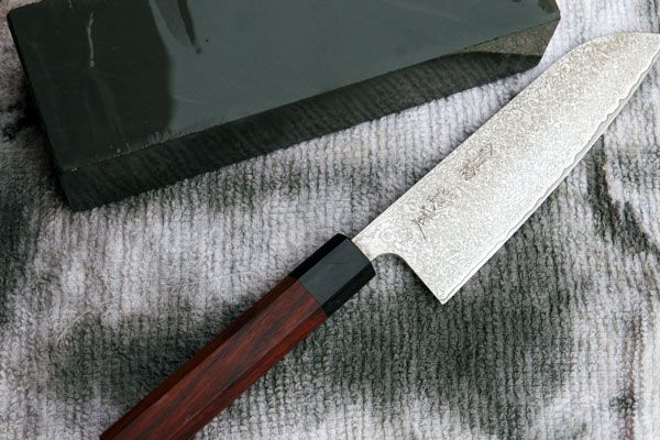 Knife set next to a whetstone on a towel