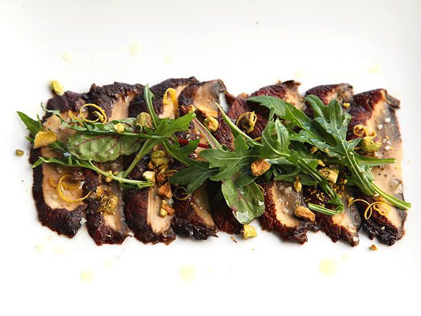 Overhead closeup of the finished mushroom carpaccio served on a white plate.