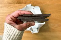 A person holding Theo Pure Dark 85% Chocolate Bars