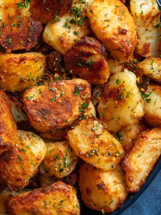 The best crispy roast potatoes ever in a bowl on a blue background.